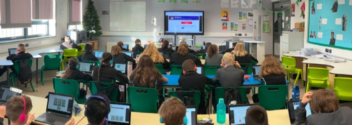 Rows of students sat at desks with computers